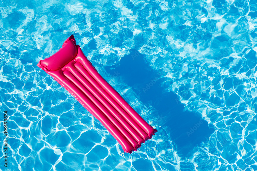 漂浮在水面上的粉红色充气床垫