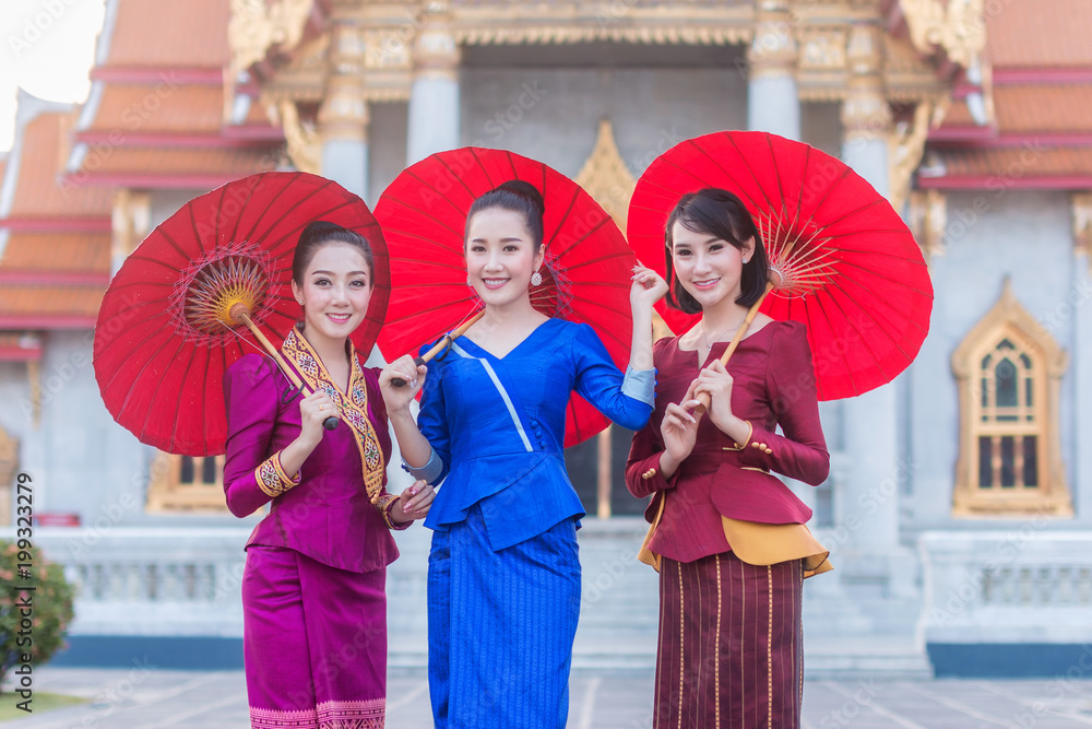 美丽的泰国女孩，穿着泰国服装，带着雨伞。