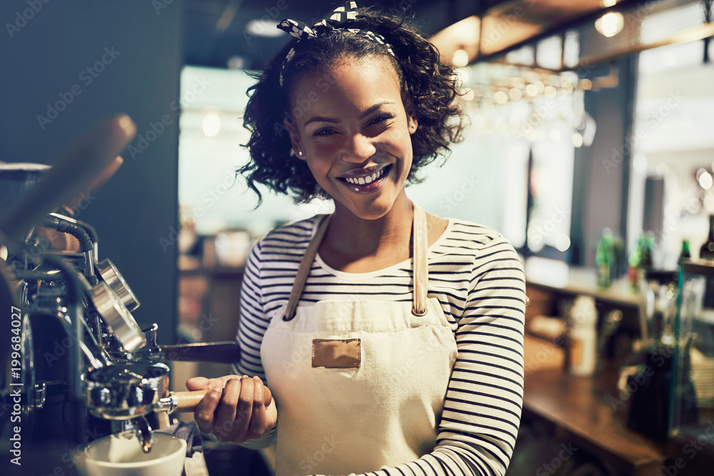 微笑的年轻非洲咖啡师在咖啡馆准备新鲜咖啡