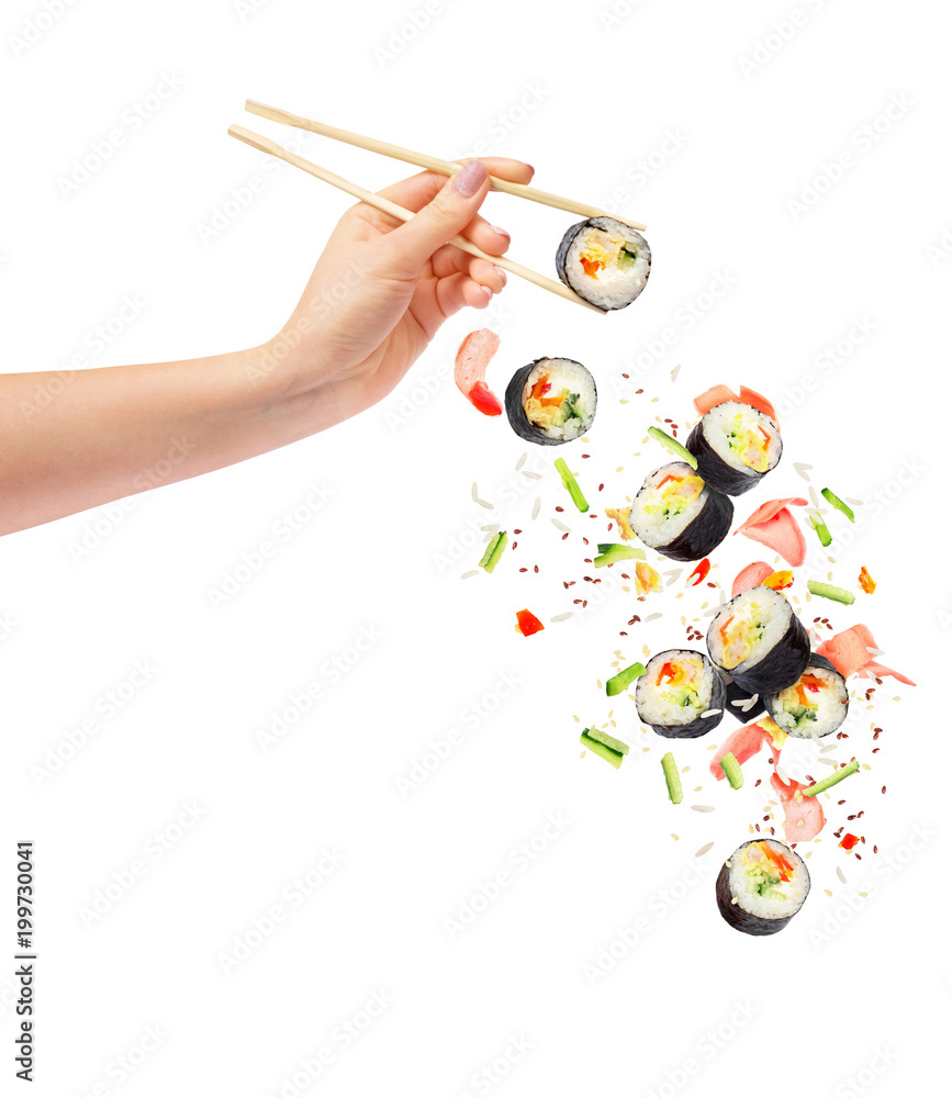 女性手中拿着木筷子的新鲜寿司和寿司卷掉落
