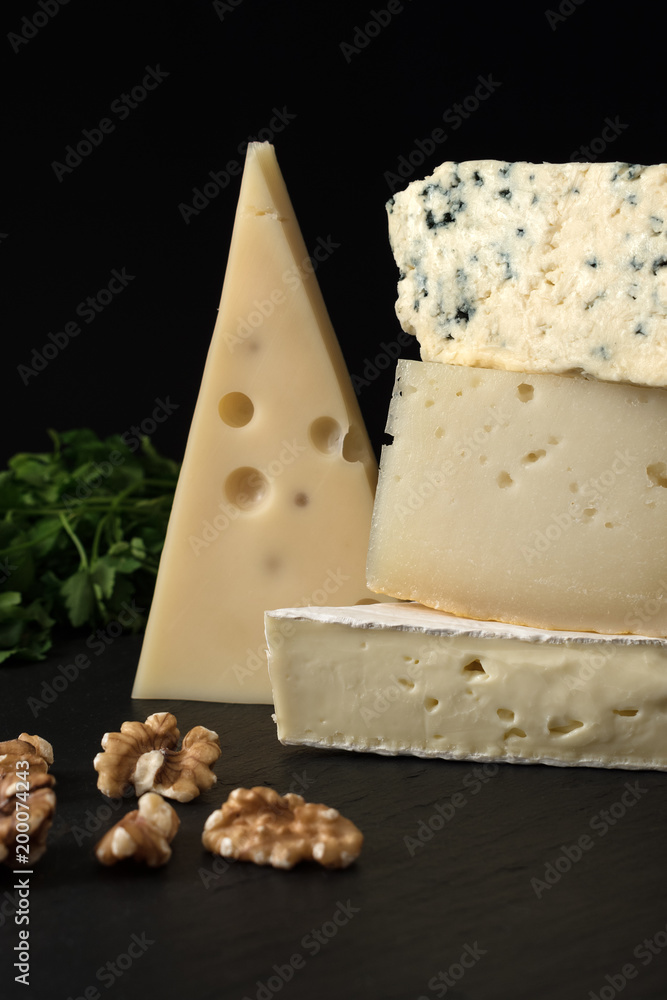 黑色石板上的各种奶酪，配上坚果和香草。