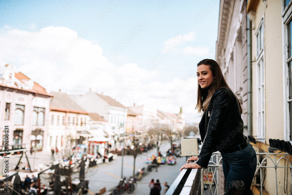 年轻女子站在城市街道的露台上。