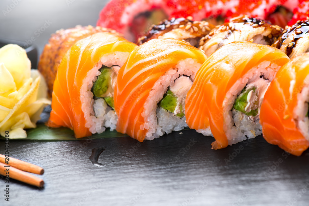 寿司卷特写。餐厅里的日本食物。三文鱼、鳗鱼、蔬菜和飞鱼卷