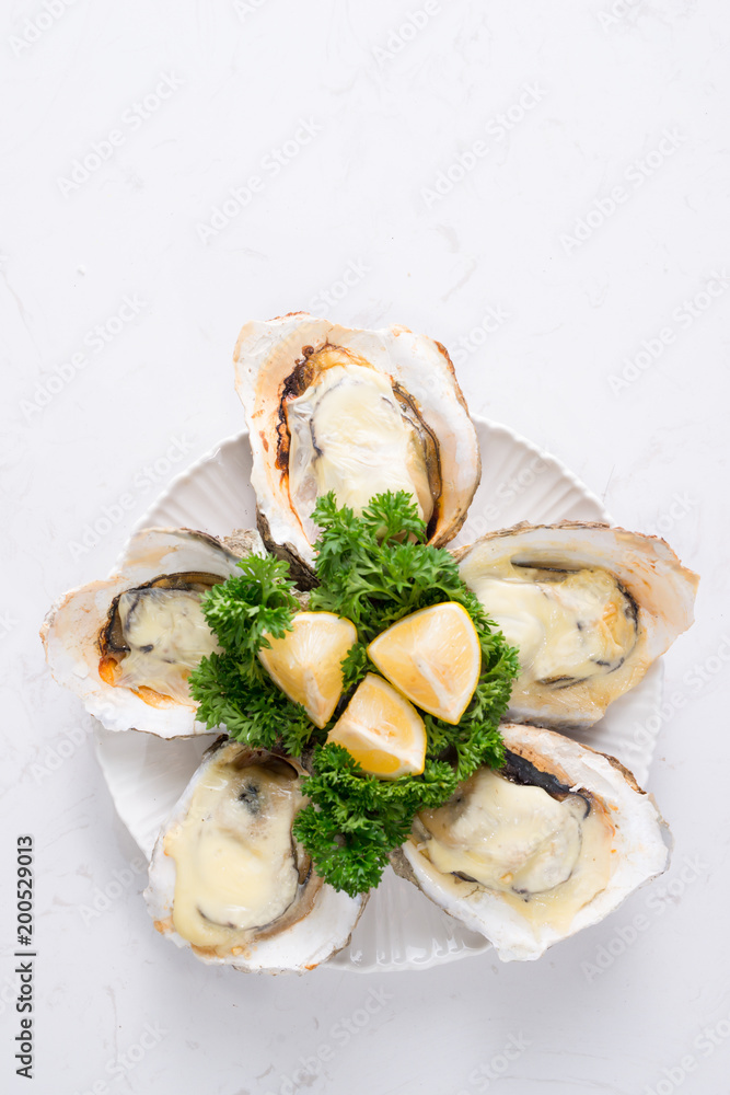 木制桌子上放着冰和柠檬的白盘子里的新鲜牡蛎