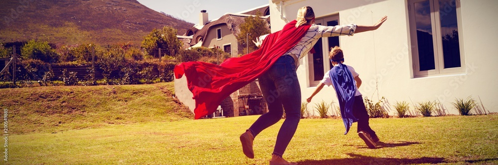 穿着超级英雄服装的母子在后院玩耍