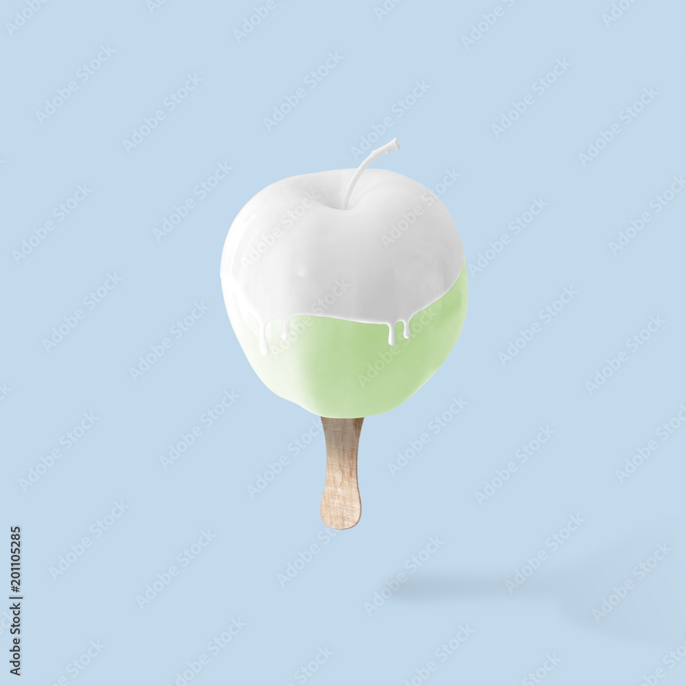 绿色苹果，蓝色背景上有冰淇淋棒。食物最少的概念。
