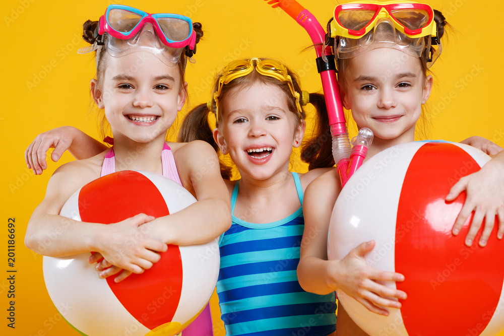 有趣有趣快乐的孩子穿着泳衣，戴着彩色背景的泳镜