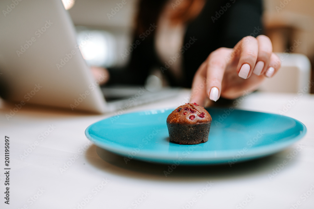 女性手拿美味的浆果松饼的特写图片。