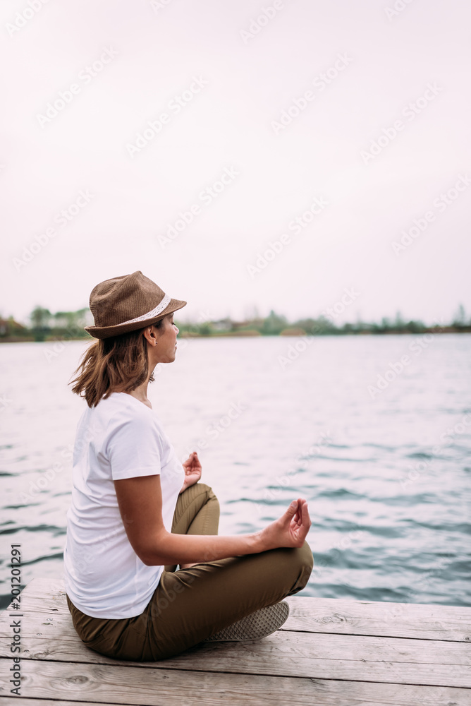 在湖边做瑜伽的女人。