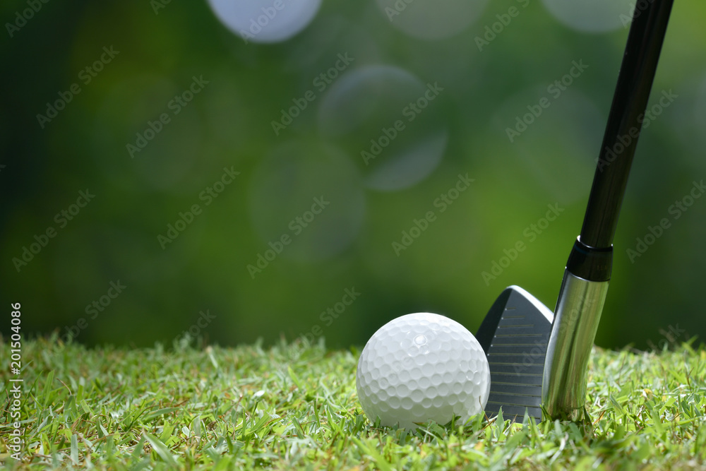 Golf ball on green grass ready to be struck on golf course background