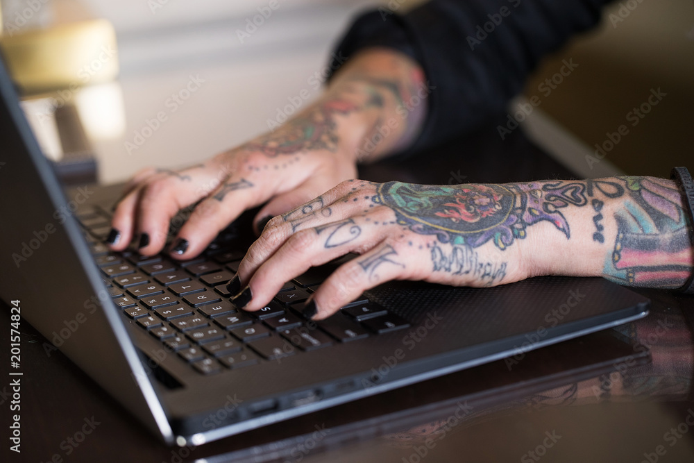 纹身手在笔记本电脑上打字
