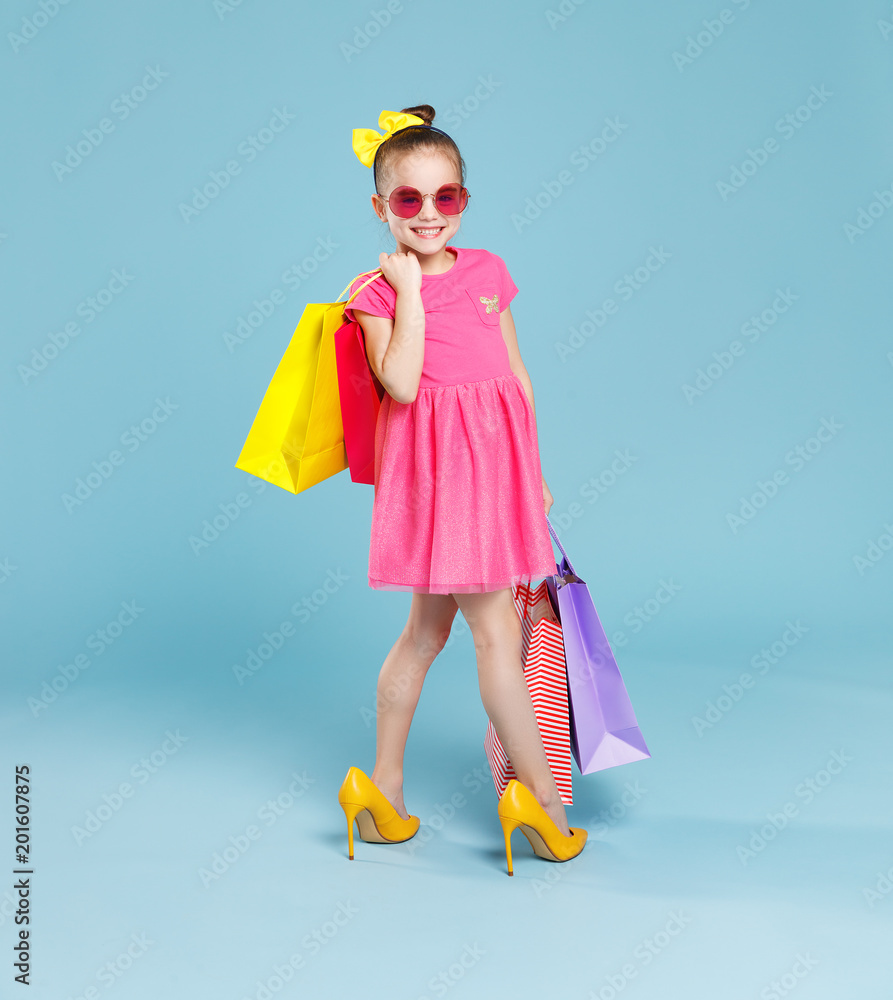 彩色背景下穿着大妈妈鞋的有趣童女时尚达人