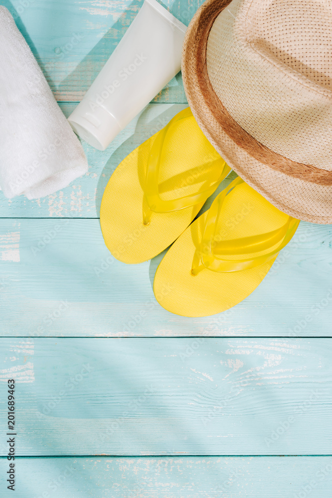 夏日背景。沙滩配饰人字拖、太阳镜、帽子和木制甲板上的橙汁