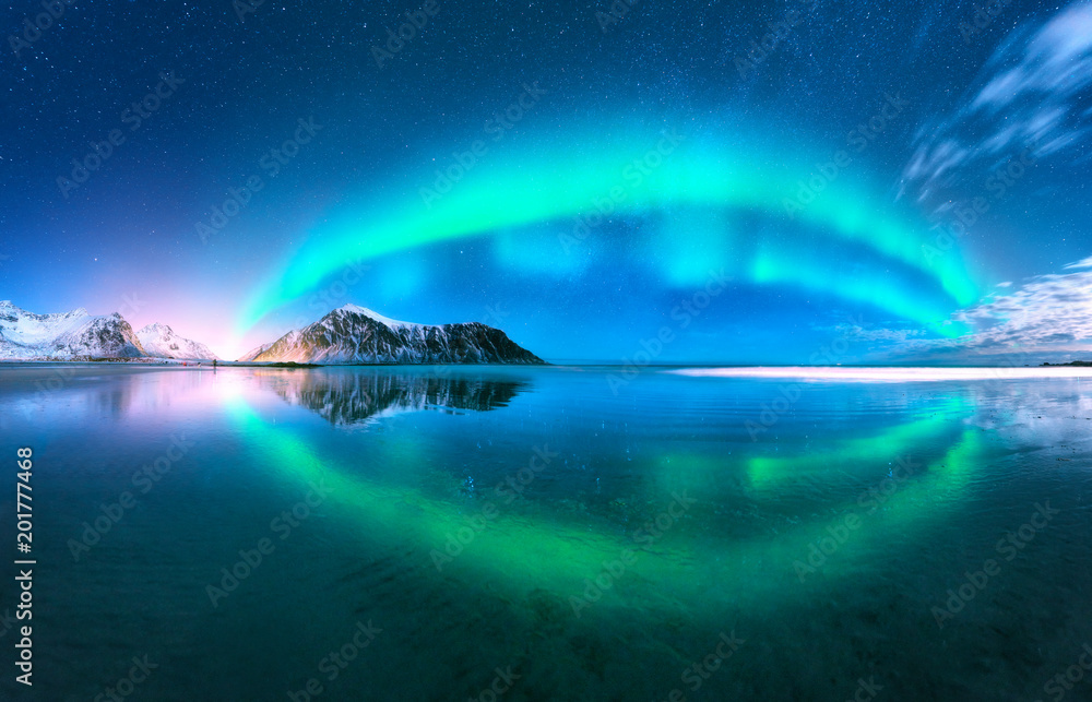 极光在水中反射。挪威罗弗敦群岛的北极光。带极光的蓝天。N