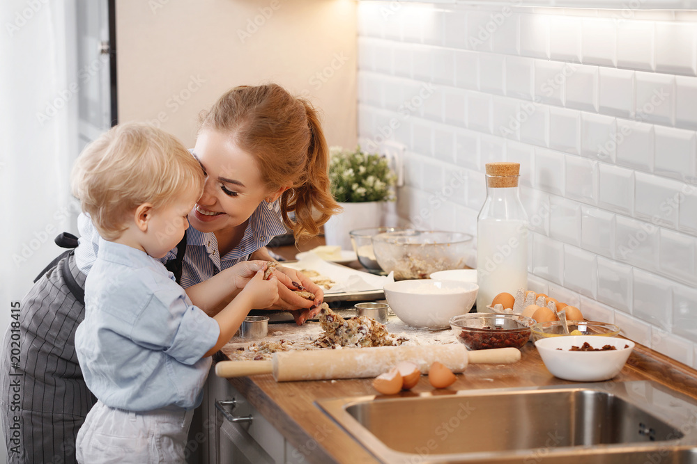 厨房里的幸福家庭。母亲和孩子在烤饼干。