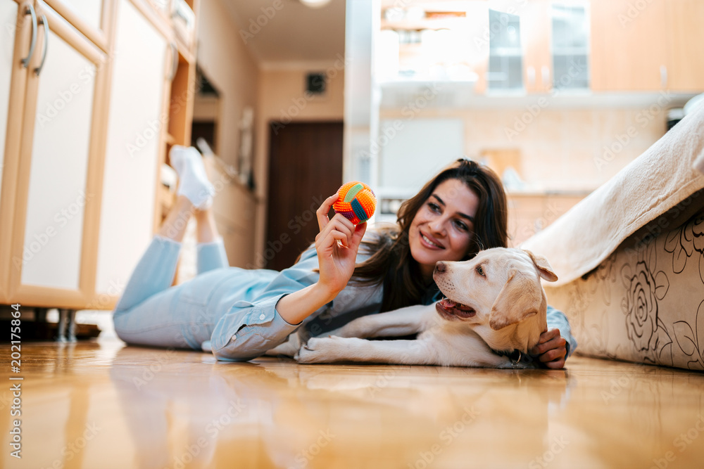 快乐的女人在公寓里和她的狗玩耍。