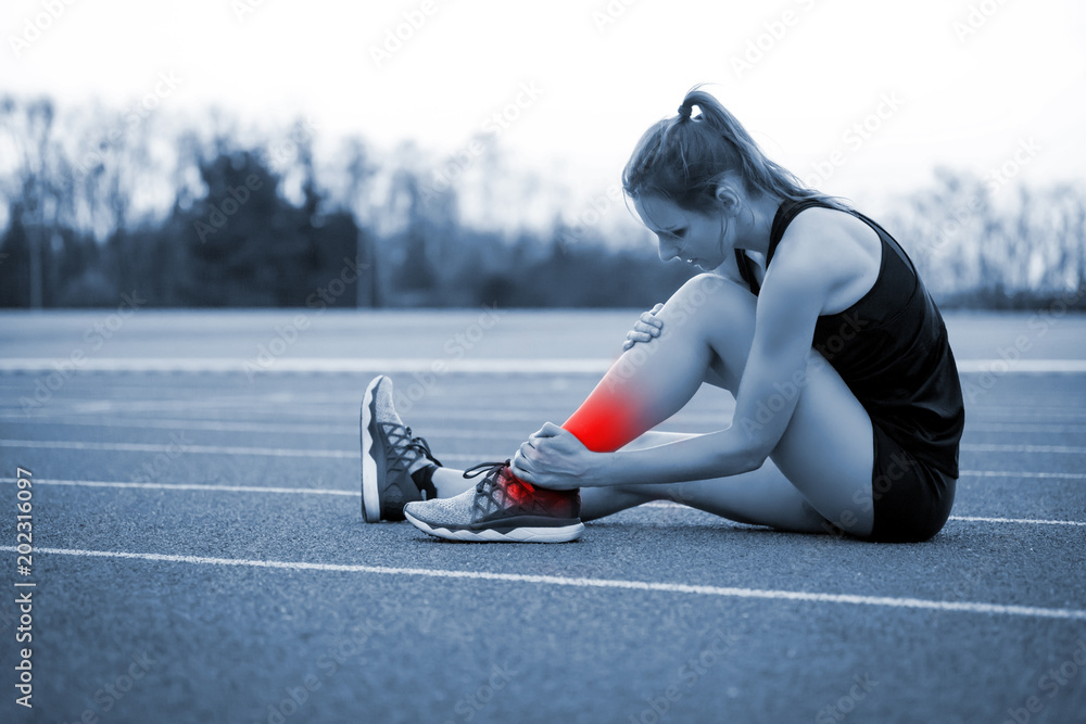 女运动员脚踝受伤，在跑步训练中扭伤了腿