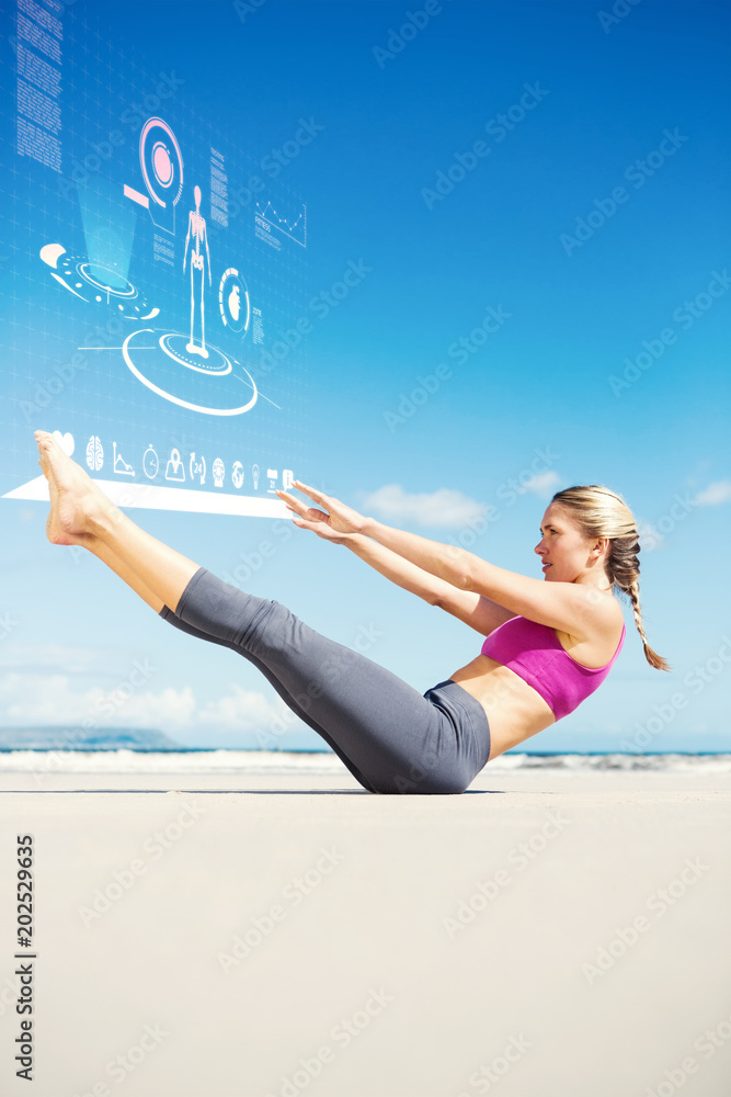专注健身的金发女郎在海滩上对着健身界面做瑜伽