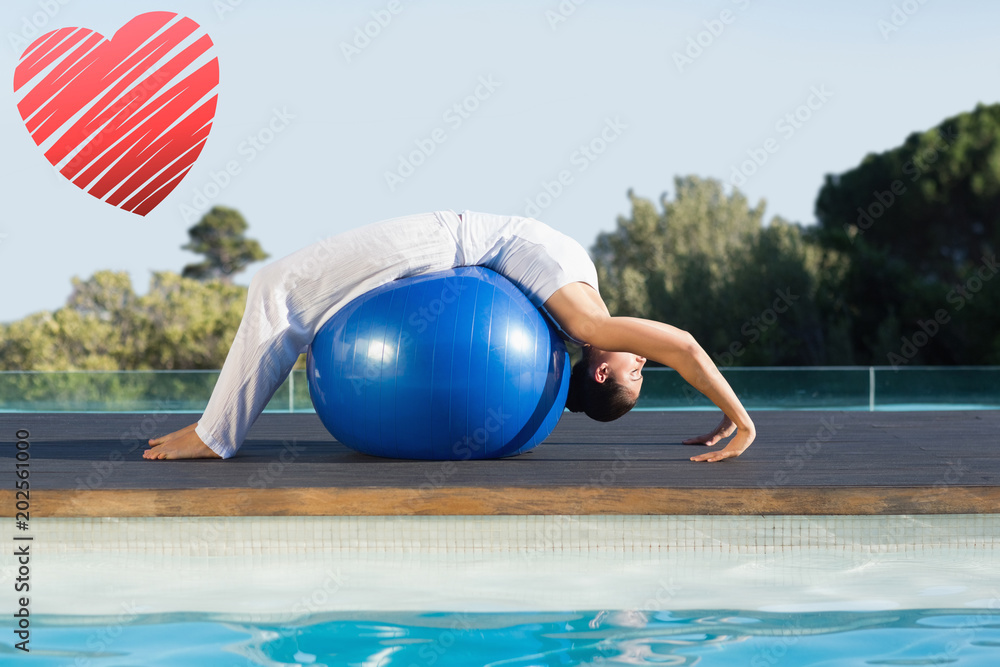 Peaceful brunette in cobra pose over exercise ball poolside against red heart