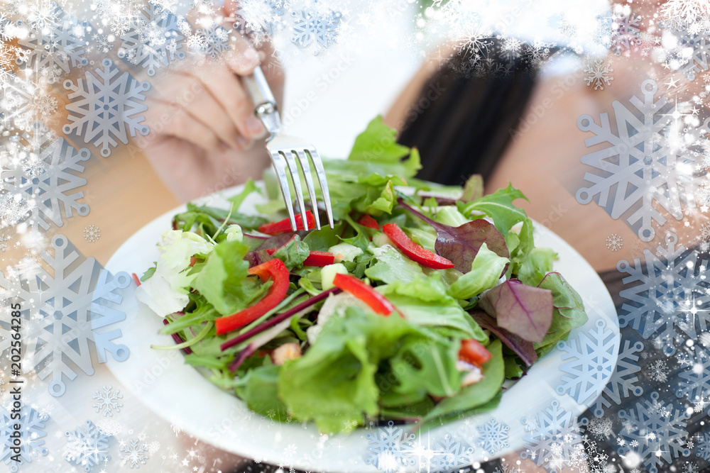一名妇女在雪中吃沙拉的特写合成图像