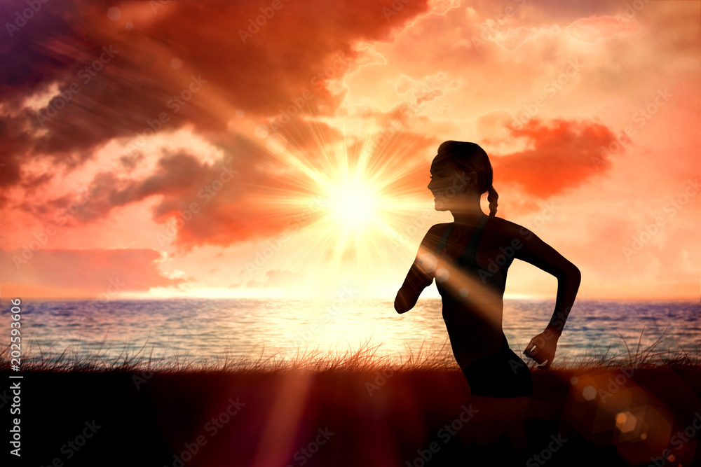 健康的女人在神奇的海洋上迎着日出慢跑