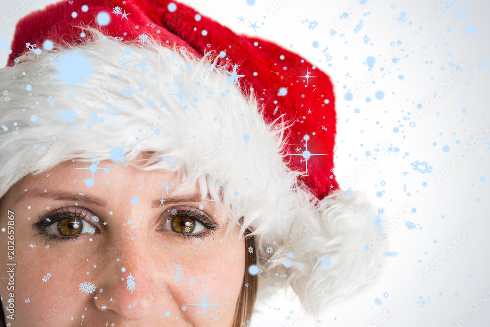 戴着圣诞老人帽的美女在雪地里微笑的特写