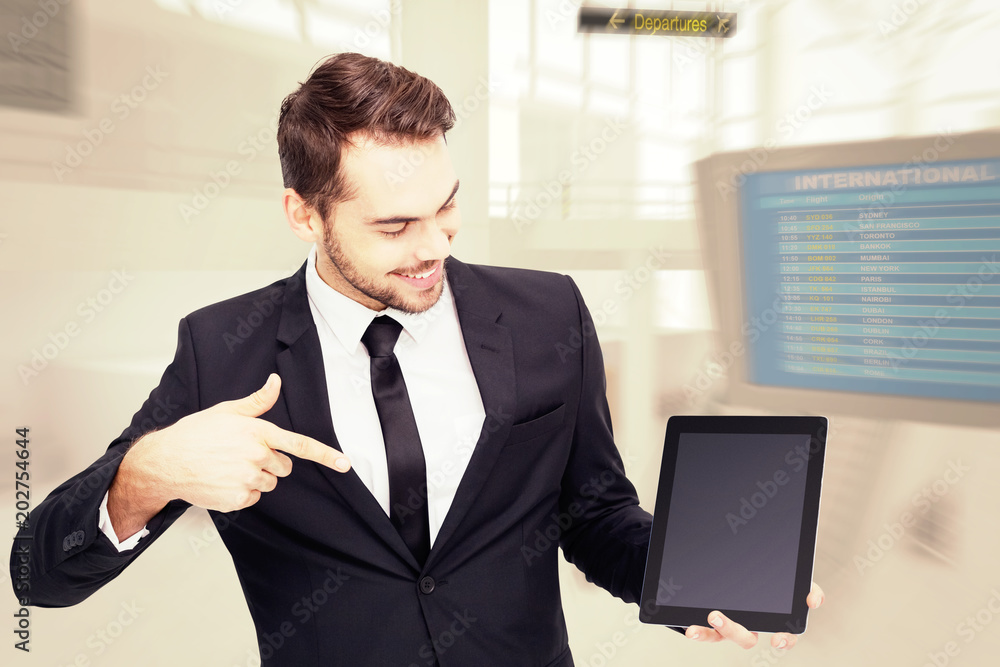 快乐的商人用平板电脑指着机场航站楼
