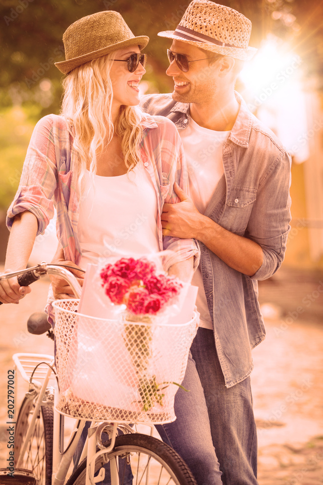城市里一对时髦的年轻夫妇在阳光明媚的日子里骑自行车