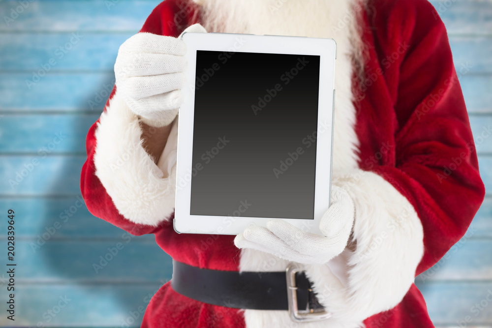 圣诞老人在模糊的木板上展示平板电脑