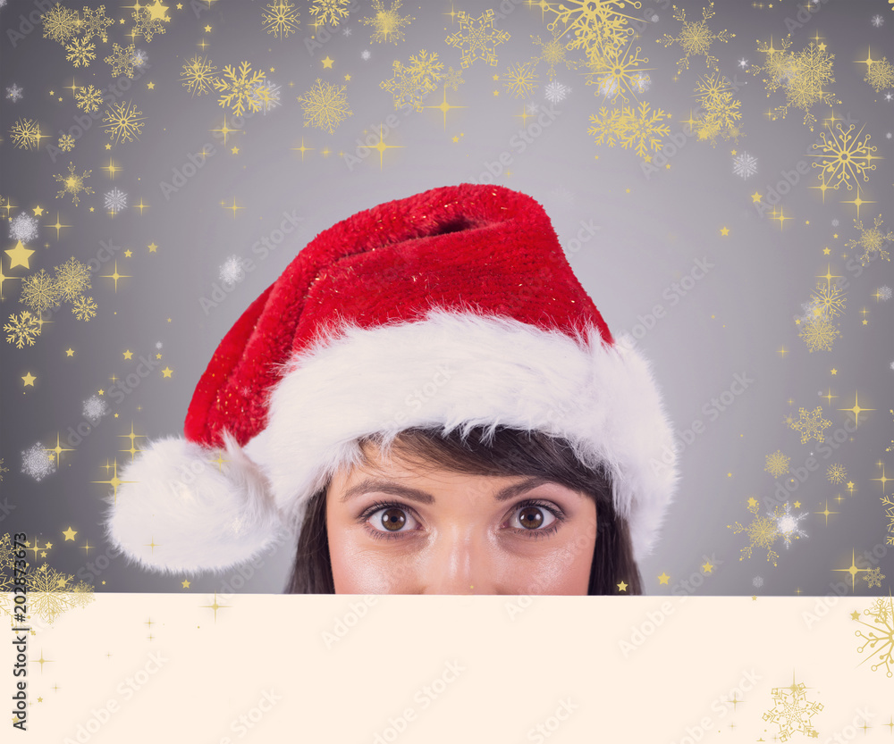 戴圣诞老人帽的漂亮女人在灰色小插曲的衬托下的特写肖像