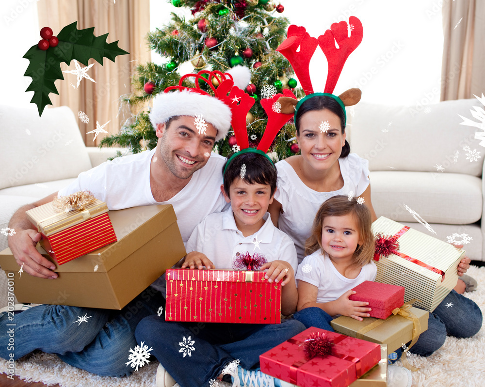 快乐的一家人在家里与红色浆果的圣诞冬青树庆祝圣诞节