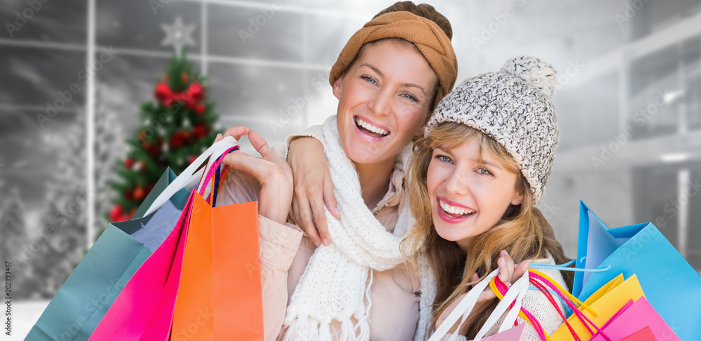 微笑的女人拿着购物袋看着相机，对着家里的圣诞树