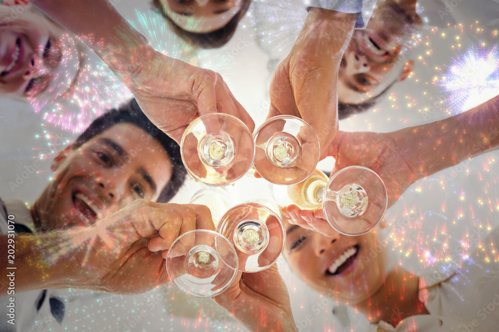 休闲商务团队用香槟举杯庆祝黑色背景上绽放的五颜六色的烟花