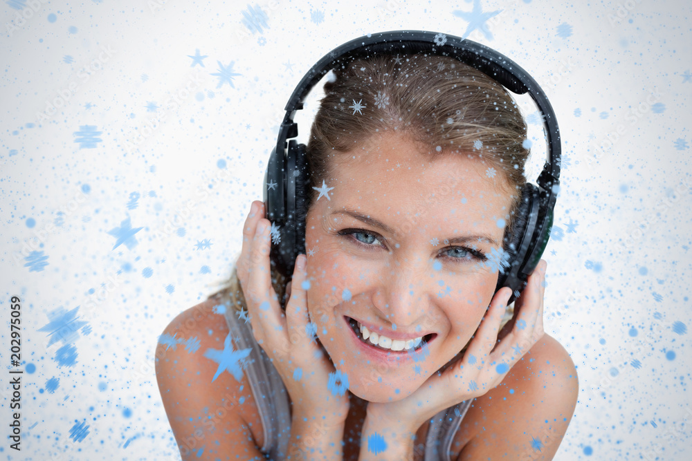 一个快乐的女人在雪地里听音乐的特写