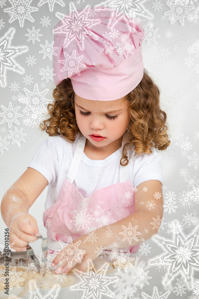 可爱的小女孩在桌子上用雪花做饼干