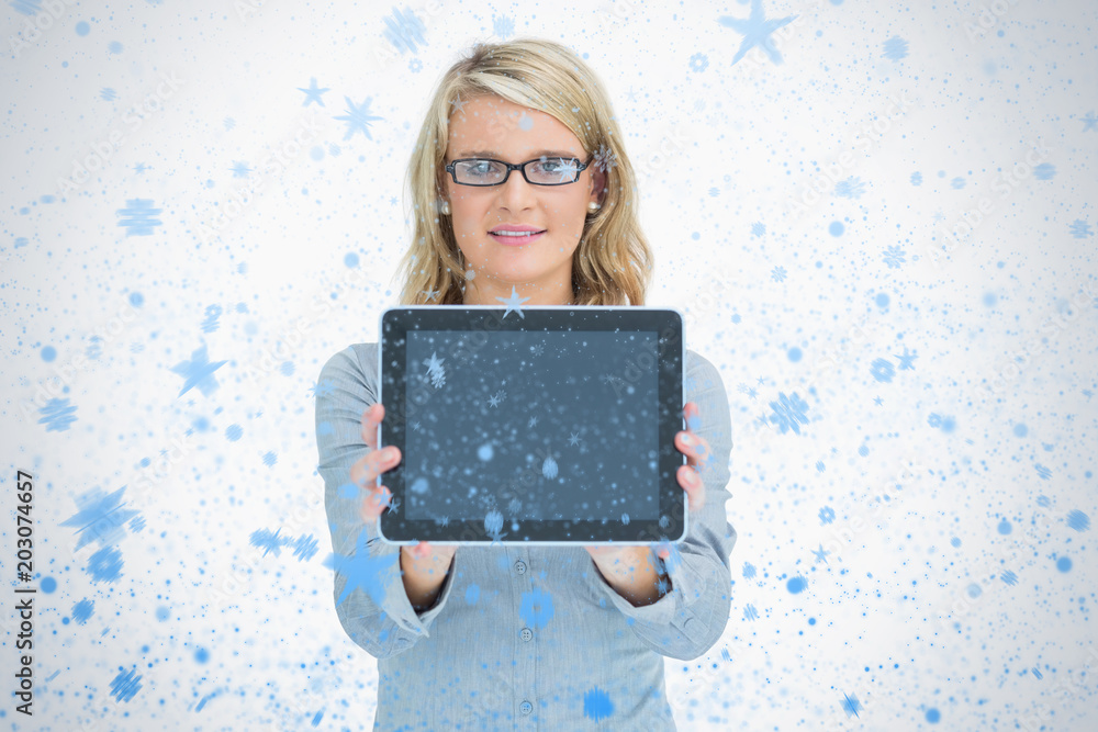 幸福的女人献上她的平板电脑抵御降雪