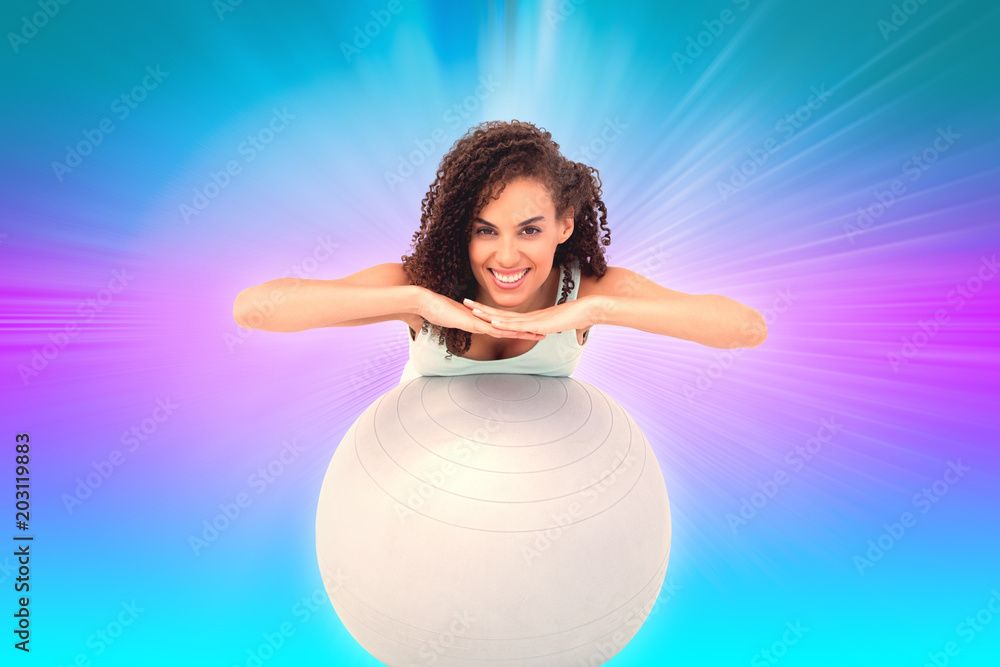 Fit woman with exercise ball against abstract background