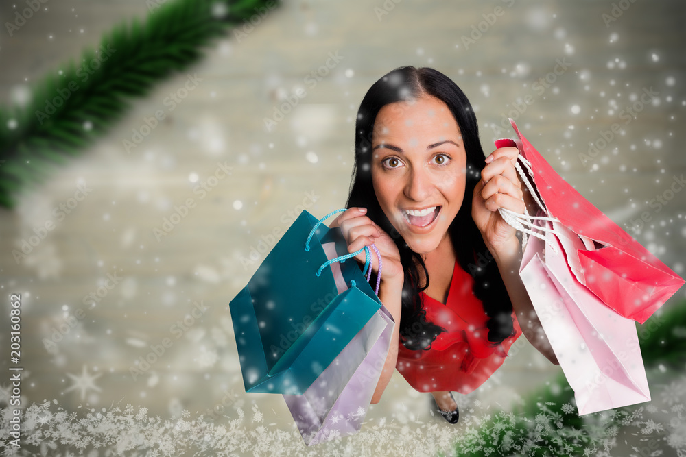 拿着购物袋站在模糊的圣诞场景下的女人