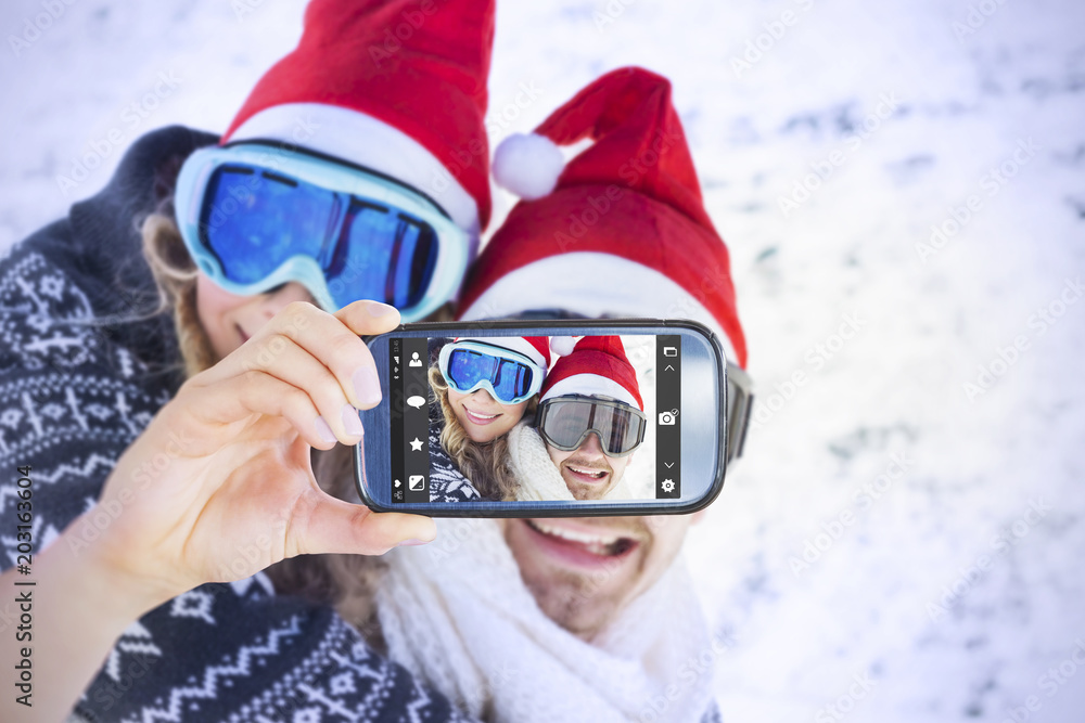手持智能手机显示男子在雪地上背着欢快的女子