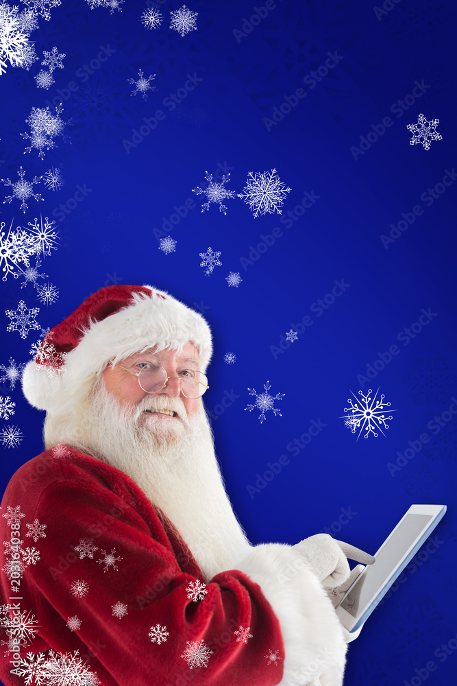 圣诞老人用平板电脑对着蓝色的相机微笑