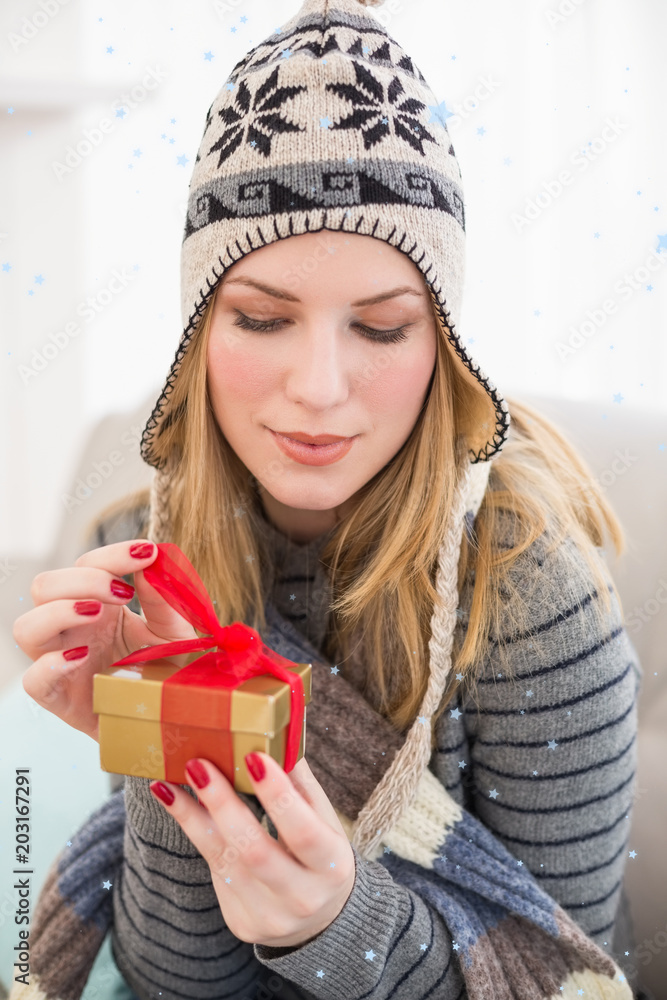 漂亮女人坐在沙发上，打开礼盒抵御降雪