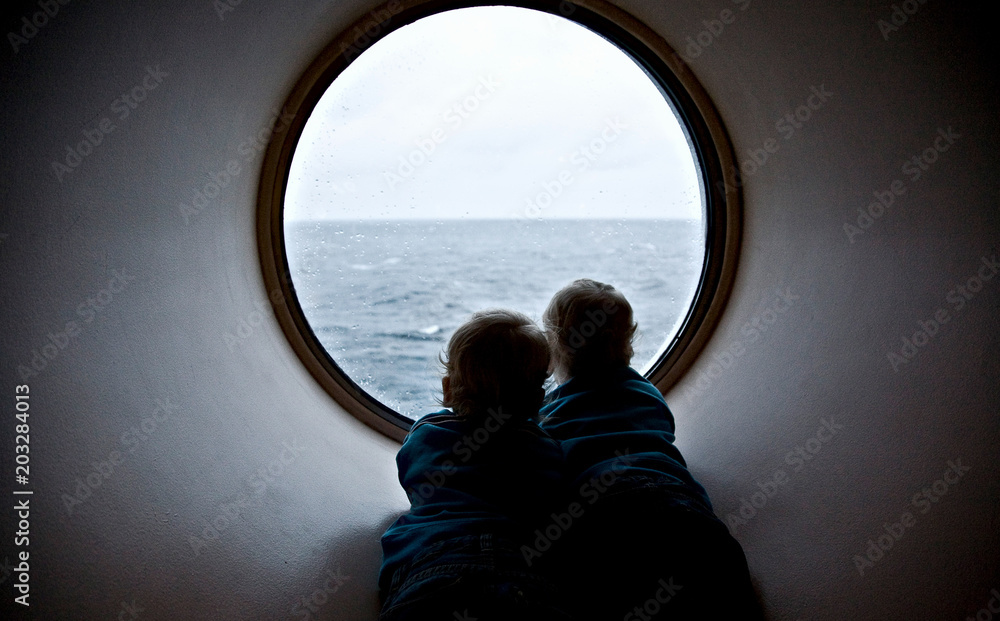 两个孩子正穿过舷窗、渡轮、秋天、波罗的海