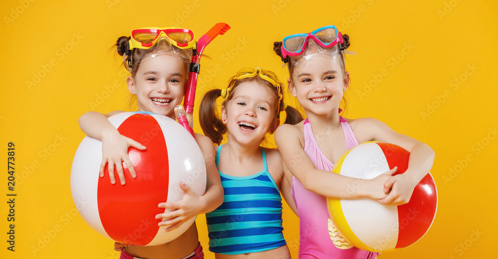 有趣有趣快乐的孩子们穿着泳衣在彩色背景上跳跃