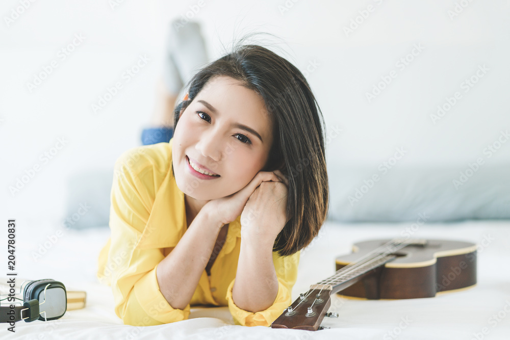 业余音乐ukelele与穿着黄色衬衫的亚洲美女一起度过幸福时刻唱歌和演奏u