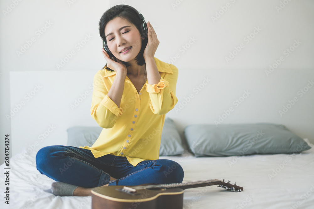 业余音乐ukelele与穿着黄色衬衫的亚洲美女一起快乐的时刻唱歌和演奏u