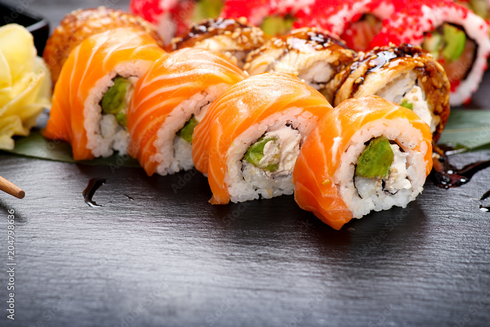 寿司卷特写。餐厅里的日本食物。三文鱼、鳗鱼、蔬菜和飞鱼卷