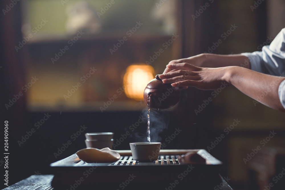 女性手从茶壶里倒茶