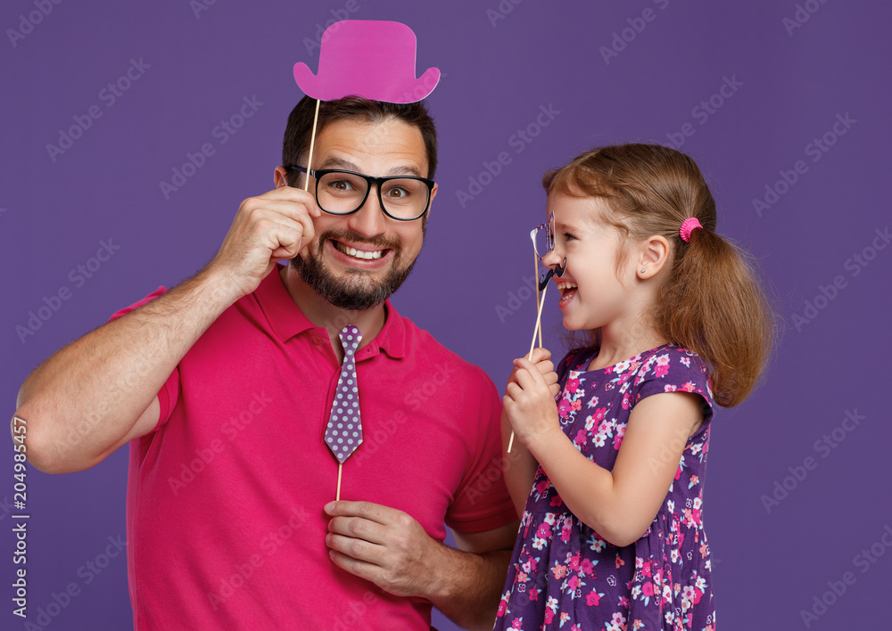 父亲节快乐！有趣的父亲和留着胡子的女儿在紫色背景上嬉戏