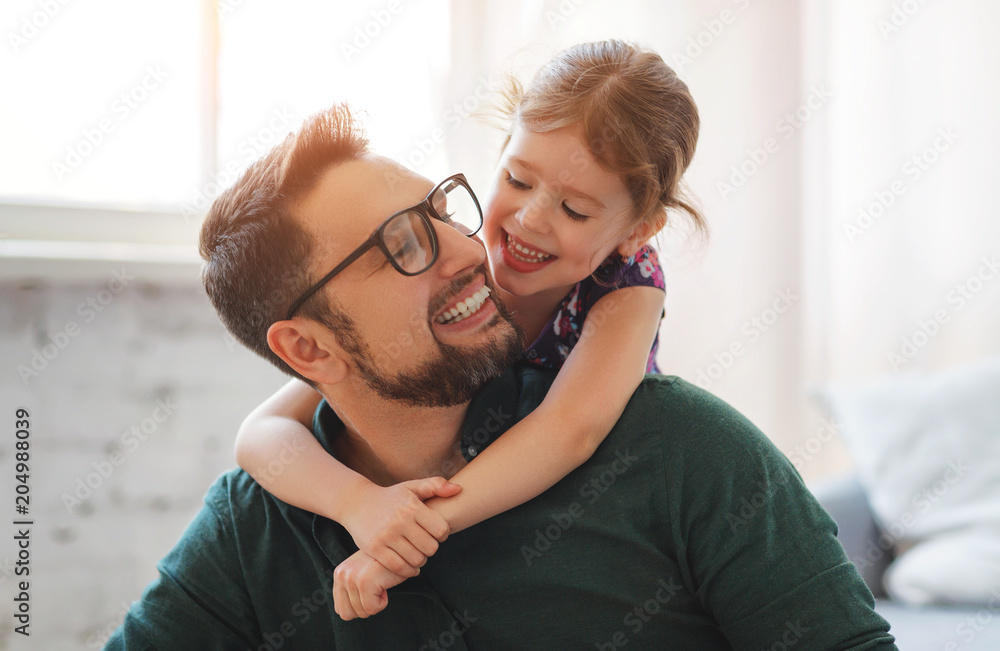 父亲节。幸福的家庭女儿拥抱他的父亲
