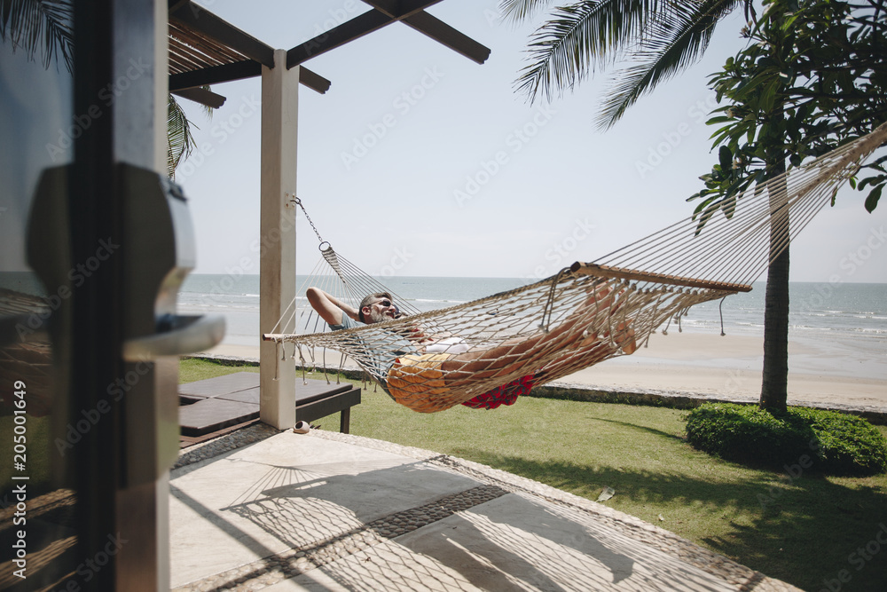 情侣在海滩边的吊床上放松